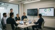 © Stocksy - Business meeting with people around a table with laptops and screens.