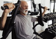 © Budimir Jevtic - Older man using fly machine for training in gym