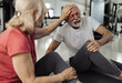 © Budimir Jevtic - Older lady comforting man after injuring leg in gym