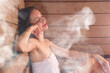 © New Africa - Beautiful woman relaxing surrounded by steam in sauna