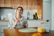 © Dusan - Young caucasian woman eating corn flakes for breakfast at home