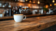 © Swaha - A perfectly crafted latte art adorns a steaming cup of coffee, resting on a rustic wooden counter in a trendy café.  The background is a blurred image of the coffee shop's interior.