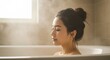 © Ura - Asian woman enjoying a soothing steamy bath moment in a bright spa-like home bathroom