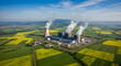 © abu - Aerial View of a Coal Fired Power Plant Emitting Smoke Surrounded by Green and Yellow Fields Under a Clear Blue Sky