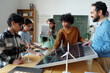 © pressmaster - Group of diverse children and teacher working in classroom on solar energy project with wind turbines, discussing and collaborating on renewable energy concepts