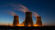 © abu - Illuminated Nuclear Power Plant Cooling Towers Emitting Smoke Under Dark Blue Evening Sky for Energy Production