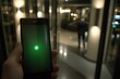 © AT - Smartphone in hand, green light, blurred background