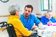 © unai - Male nurse assisting elderly woman in wheelchair at nursing home