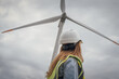 © YURIMA - A confident female engineer in a hard hat and safety vest stands proudly before a wind turbine, highlighting her commitment to renewable energy and sustainability initiatives today