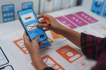 Wall Mural - ux designer working on a mobile application wireframe using a paper prototype of the user interface,