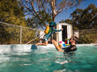 © Austockphoto - Toddler kid leaping into dads arms in backyard pool with childlike trust