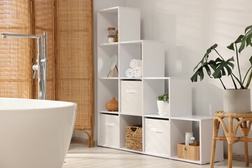 Poster - stylish bathroom with shelving unit, bathtub and houseplants