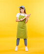 © New Africa - Happy woman with rolling pin on yellow background