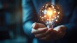 © mas - Hands holding a glowing light bulb with digital sphere, representing new ideas and innovation
