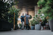 © qunica.com - People navigating an urban setting filled with lush plants, discussing work and exchanging ideas. Captures a modern workspace concept merging nature with professional environments.