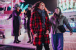 © qunica.com - A group of friends laugh and enjoy themselves at a colorful carnival, surrounded by lights and rides, embodying moments of joy and friendship during a fun-filled evening outing.