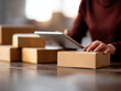 © Nakarin - Person handling cardboard box and using tablet for logistics, showing eco conscious packaging and careful work in warm setting