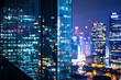 © Yana - Night Cityscape View Through Glass with Blurred Office Building Lights and Urban Skyline