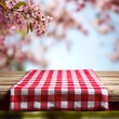 © Tmack - Picnic table setting with red checkered tablecloth and cherry blossoms against blue sky background isolated on png transparent background