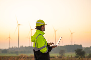 Wall Mural - engineer with laptop survey work in wind turbine farms rotation to generate electricity energy. main