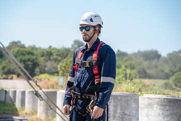 Wall Mural - engineer wearing uniform inspection and survey work in wind turbine farms rotation to generate elect