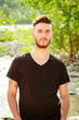 © theartofphoto - Man standing by a river in natural light during daytime