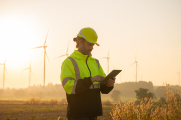Aufkleber - Engineer man working with tablet at windmill farm Generating electricity clean energy. Wind turbine farm generator by alternative green energy.