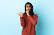 © luismolinero - Delivery African American man with braids isolated on white background pointing to the side and doing silence gesture