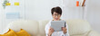 © satura_ - Woman using tablet while sitting on cozy couch at home. Technology and digital lifestyle concept. Banner with copy space
