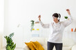 © satura_ - Joyful woman listening to music and dancing at home. Freedom, relaxation and happiness concept. Copy space