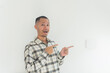 © Tito Rollis - Young Adult Asian men wearing flannel pointing fingerwith smiling face and exited expression with isolated white background
