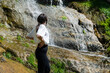 © boryanam - Young woman standing in front of a spring waterfall