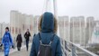 © mediawhalelicensing  - Woman walking on bridge as people approach from distance. Action