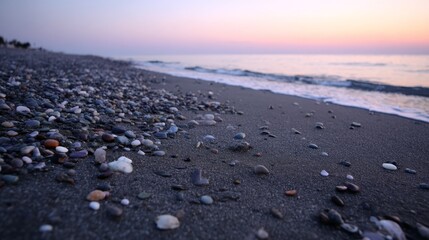 Poster - At dawn, gentle waves lap against smooth pebbles on a peaceful shoreline, showcasing a gradient sky of peach and violet perfect for relaxation and travel inspiration
