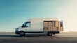 © Nice Seven - A white delivery van loaded with cardboard boxes, parked on an open road under a clear sky.