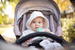 © splitov27 - Little cute baby wearing hoodie chewing teether, sitting in stroller outdoors