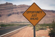 © Mirivox - Orange diamond-shaped road sign against blurred desert landscape, displaying 'Opportunity Just Ahead,' conveying optimism and anticipation for future success