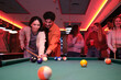 © Ladanifer - Group of friends enjoying a game of pool in a lively nightclub