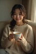 © kineter_ai - Smiling Japanese Woman in Cozy Sweater Holding Tea Cup, Seated Peacefully on a Soft Sofa - Relaxing Winter Afternoon at Home