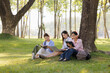 © Wanchai - A group of female students sits under a tree in the park, laughing and chatting joyfully together.
