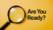 © Mirivox - Magnifying glass on yellow background with text 'Are You Ready?'  Symbolizes preparation, investigation, or a call to action