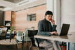 © Zamrznuti tonovi - Asian businesswoman working on laptop in modern office