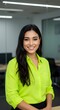 © Gennyson Marinho - Portrait of a smiling woman with long dark hair wearing a bright green shirt indoors