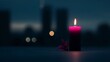 © DIAHIMAGESNEW - A single, burning pink candle, a symbol of remembrance, sits on a dark surface, with a delicate flower petal nearby, in front of a softly lit city skyline