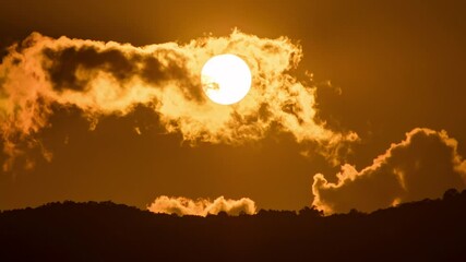 Wall Mural - timelapse of dramatic sunset with orange sky in a cloudy day.