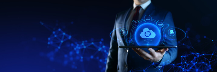Wall Mural - businessman holding tablet with cloud computing icons on screen. data transfer and cloud backup tech