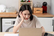 © Kawee - Asian young businesswoman typing on laptop and overworking from home.