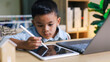 © Smile Studio AP - Kid using tablet for his homework,Child doing using digital tablet searching information on internet while school .