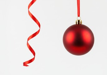Wall Mural - Festive red christmas ornament hanging with matching ribbon on a clean white background for holiday cheer