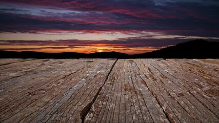 Wall Mural - weathered wooden planks framing vibrant sunset colors spreading across tranquil horizon with dramati